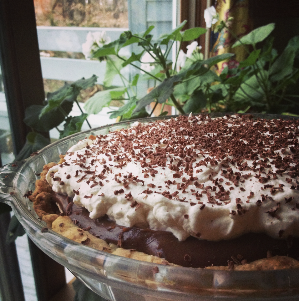 Homemade chocolate banana cream pie topped with fresh whipped cream and chocolate shavings