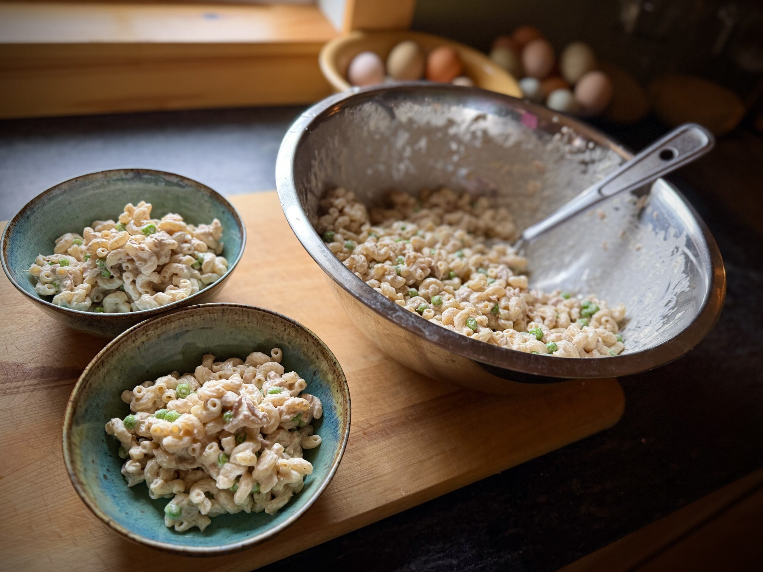 tuna macaroni salad served in bowls with peas and creamy dressing