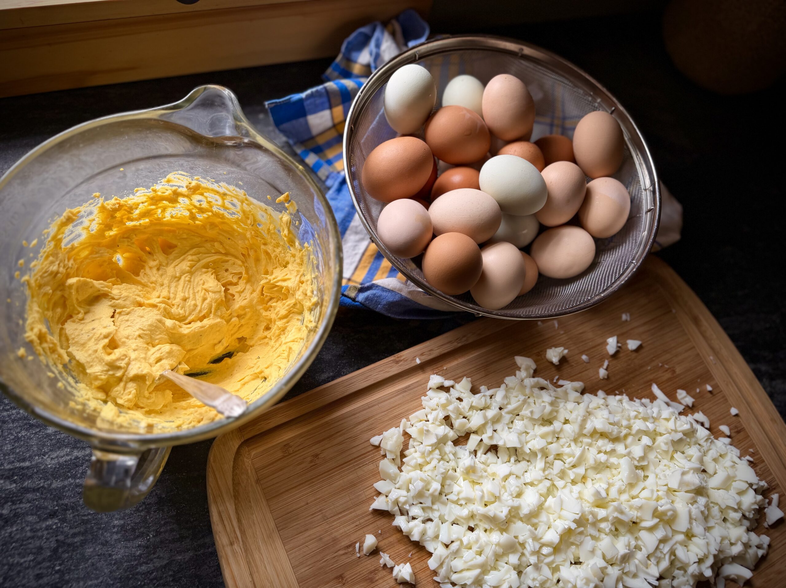 Chopped hard boiled eggs and creamy homemade dressing being mixed for classic egg salad with farm fresh eggs in a homestead kitchen