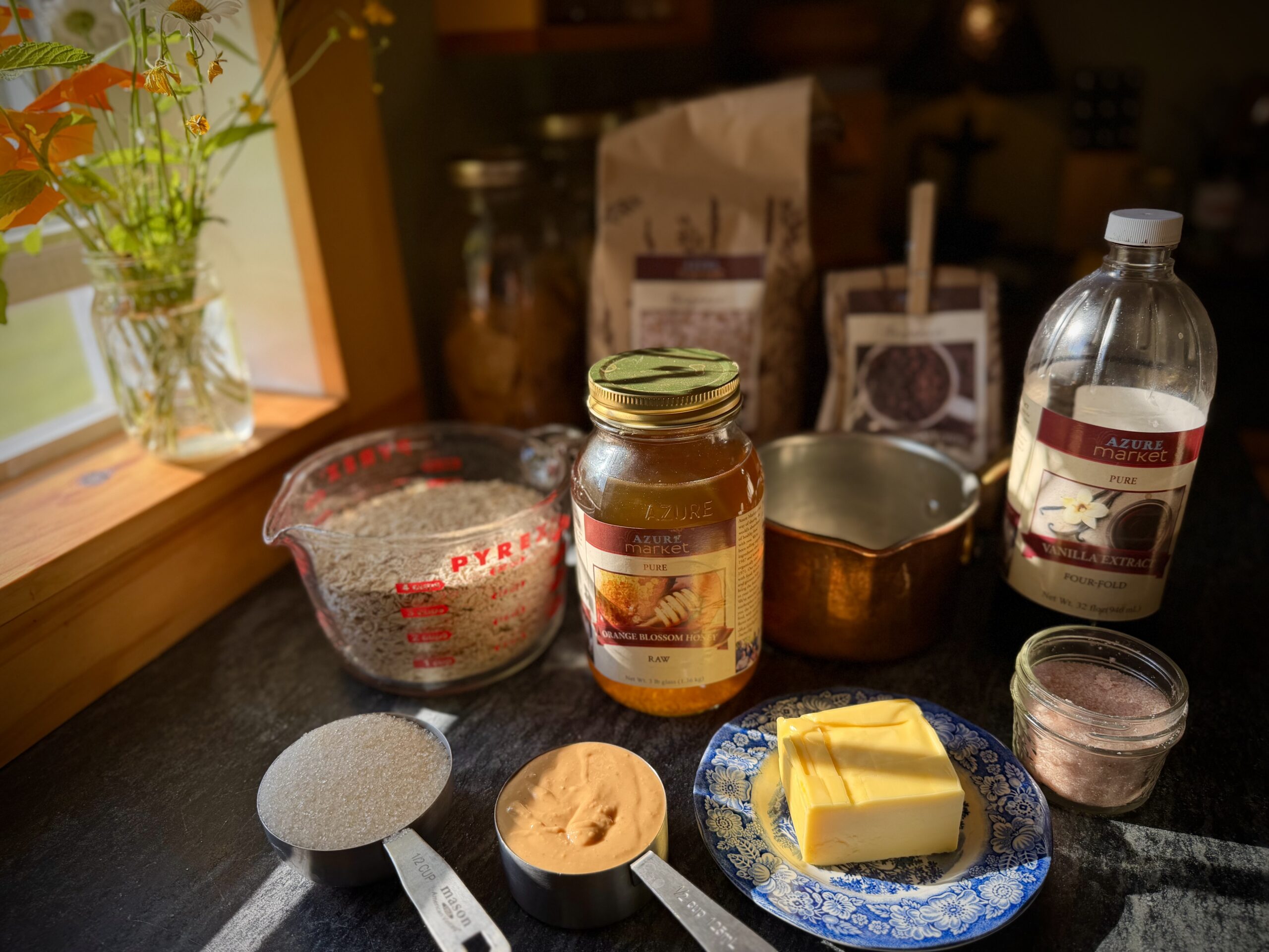 Ingredients for chewy chocolate chip granola bars, including oats, honey, peanut butter, butter, sugar, vanilla, and salt.