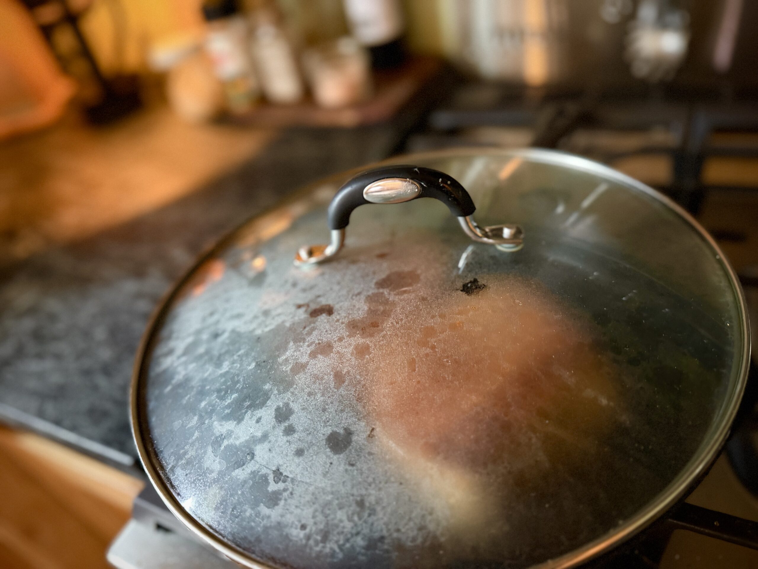 Tomato grilled cheese cooking slowly in a covered cast iron skillet