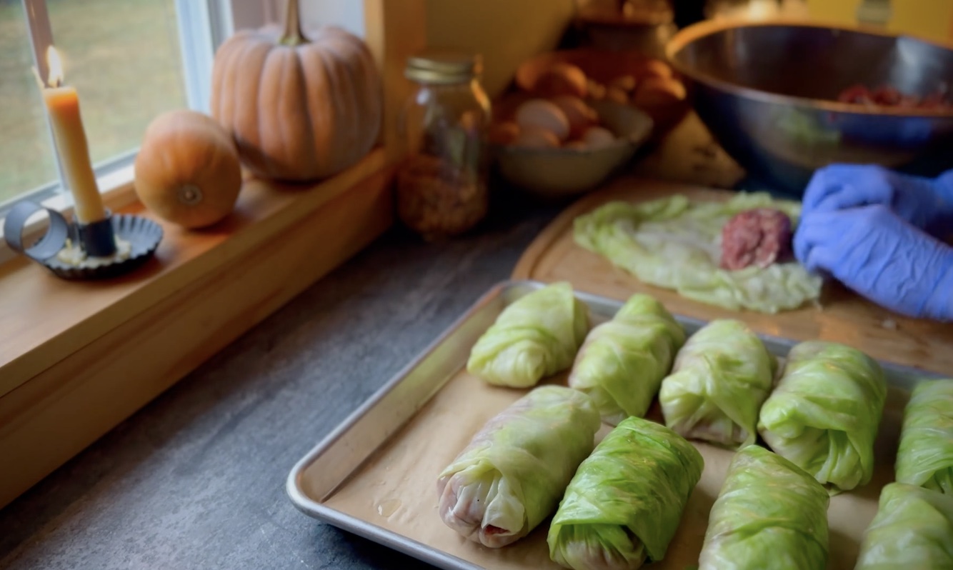Rolling homemade stuffed cabbage with ground beef filling and softened cabbage leaves.